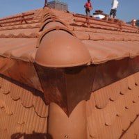Détail de faîtière avec une pièce d'about ronde
